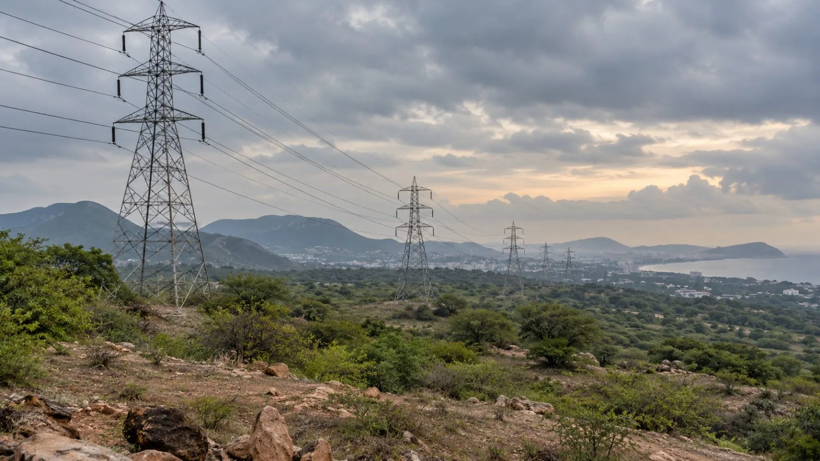 High-voltage transmission towers cross the outskirts of Visakhapatnam, Andhra Pradesh, India. (AI-generated image / EconoTimes)