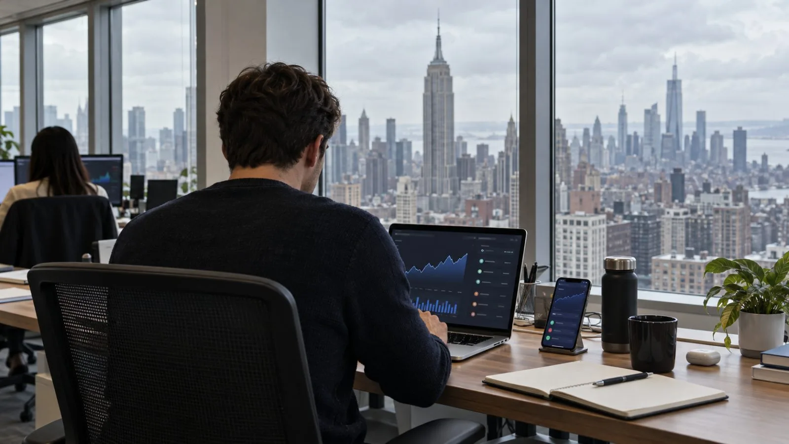 A worker reviews a transaction on a laptop in an office in New York City. (AI-generated image / EconoTimes)