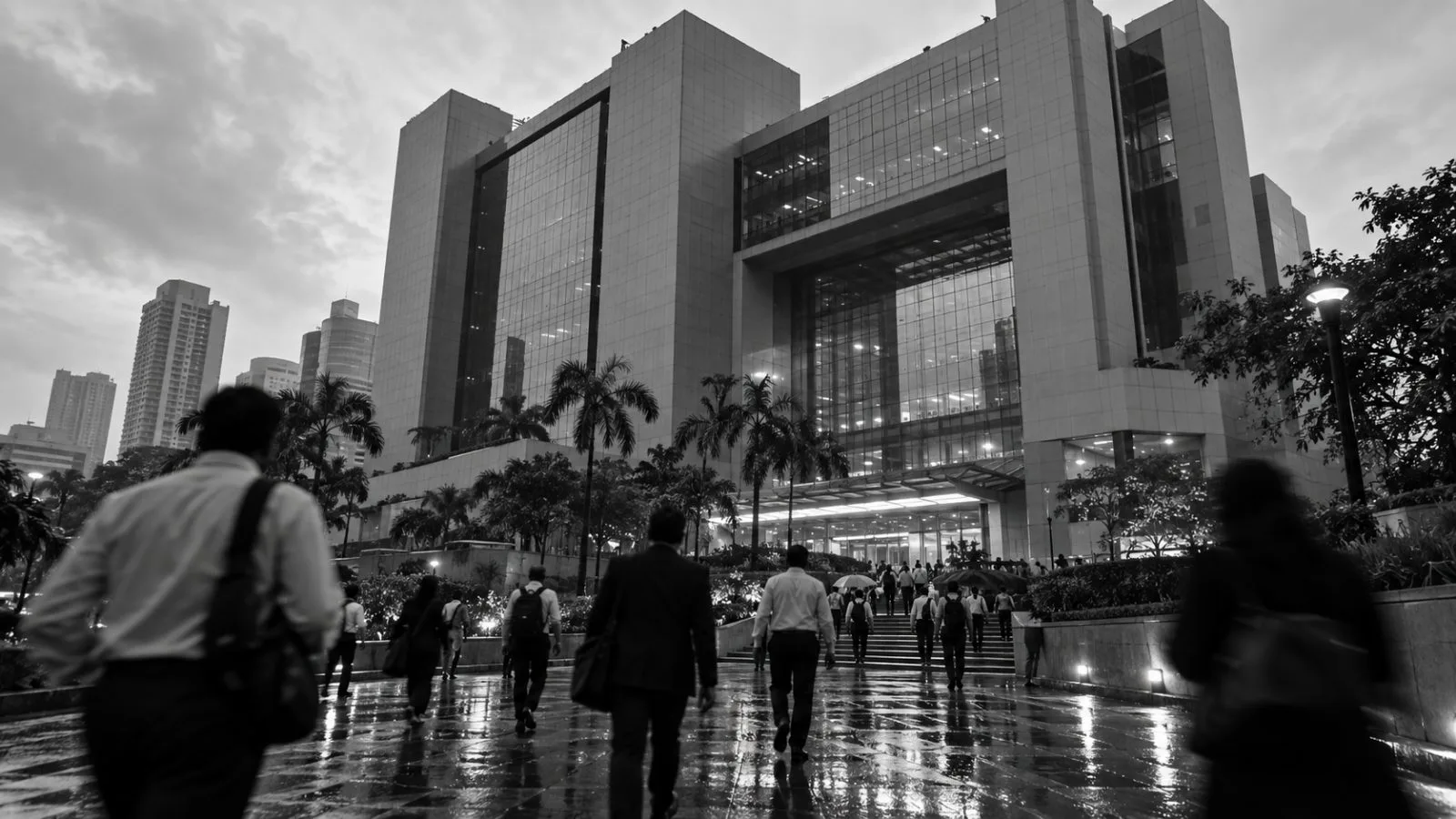 Commuters pass the National Stock Exchange building in Mumbai, India, on a cloudy morning. (AI-generated image / EconoTimes)