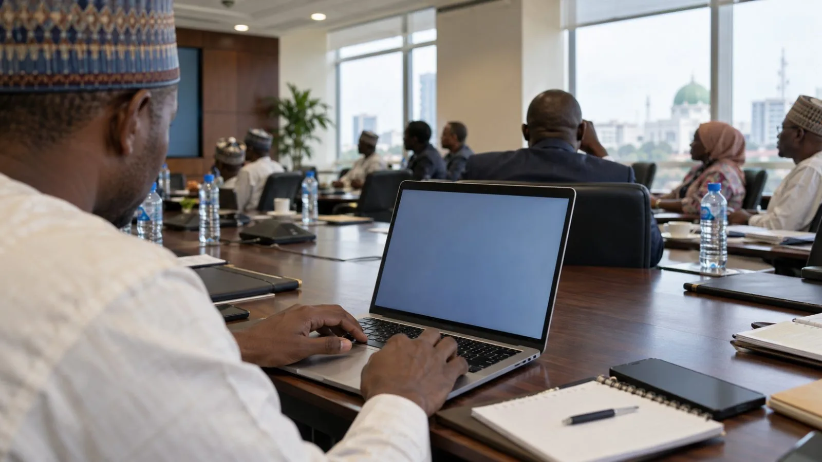 Trade officials examine a laptop during a portal demonstration in Abuja, Nigeria (AI-generated image / EconoTimes)