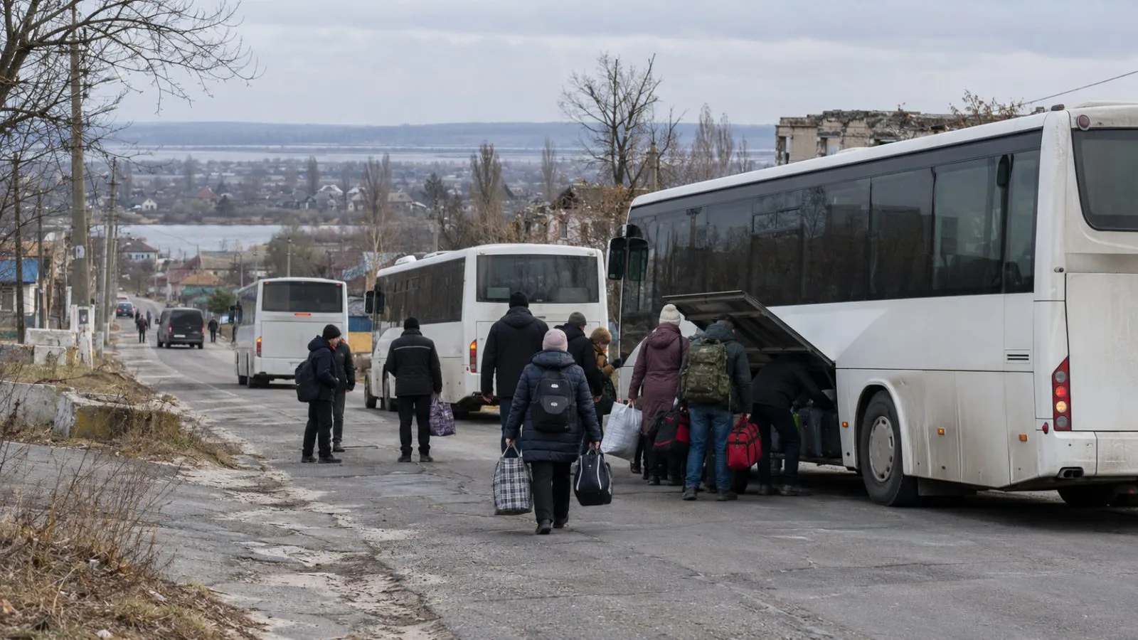 Buses prepare to carry residents away from Oleshky, Ukraine, along a road out of town. (AI-generated image / EconoTimes)