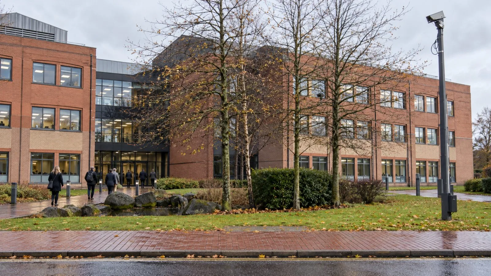 Staff enter the grid operator's headquarters in Warwick, England, on an overcast morning. / EconoTimes.ai