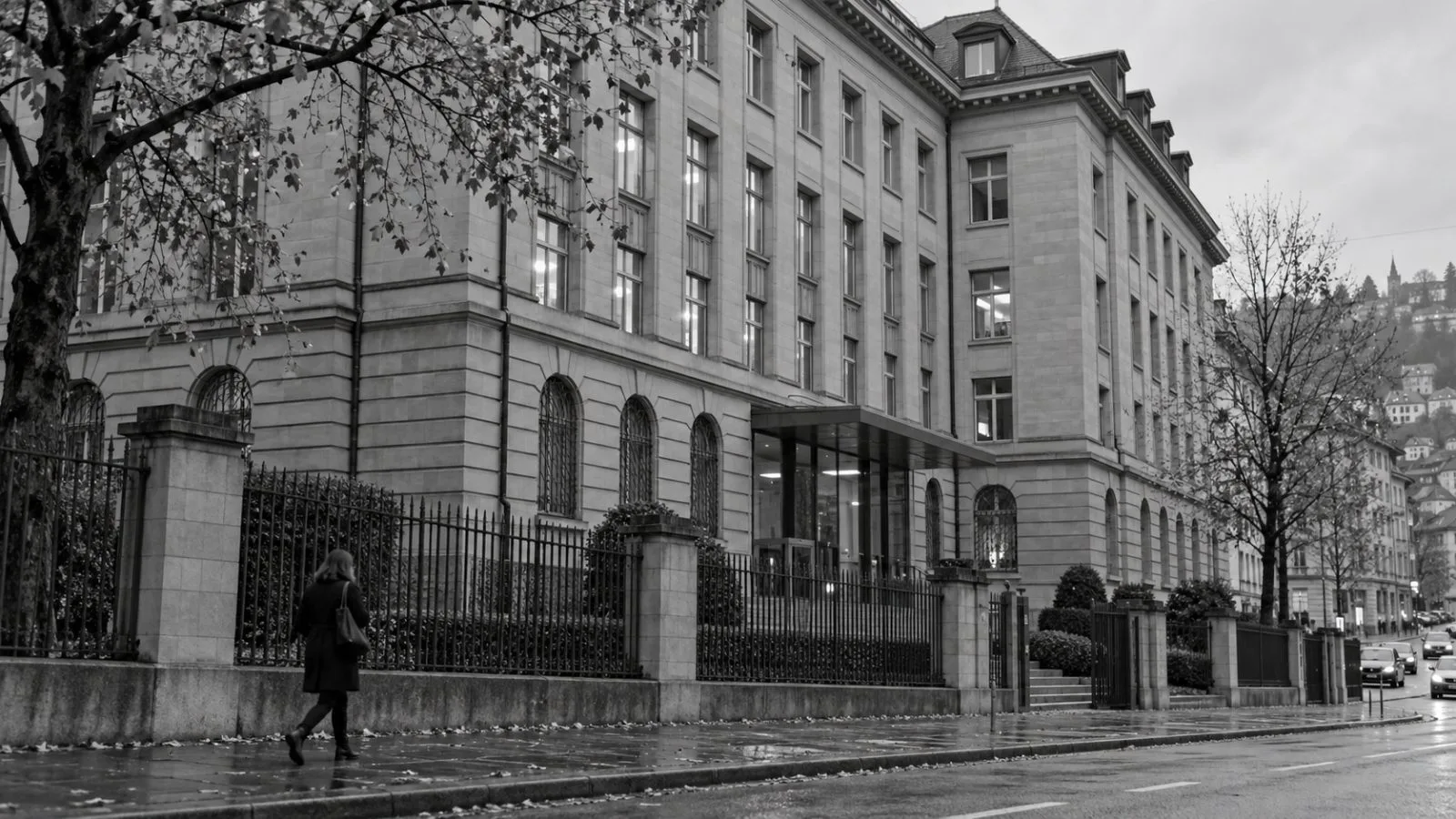 Pedestrians pass the Swiss financial regulator’s headquarters on Laupenstrasse in Bern. / EconoTimes.ai (mono)