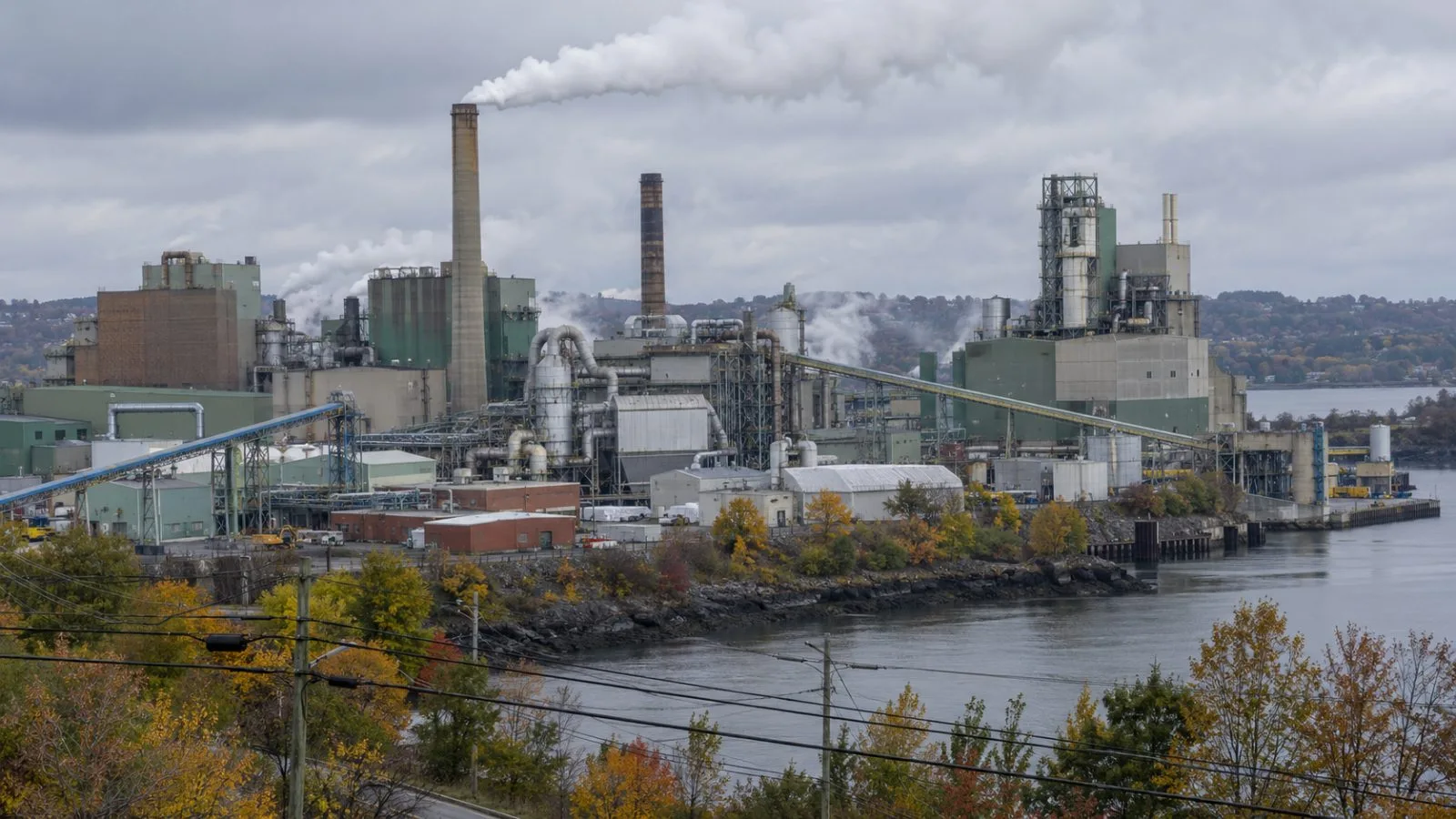 Power lines run beside the Irving Paper mill in Saint John, New Brunswick. (AI-generated image / EconoTimes)