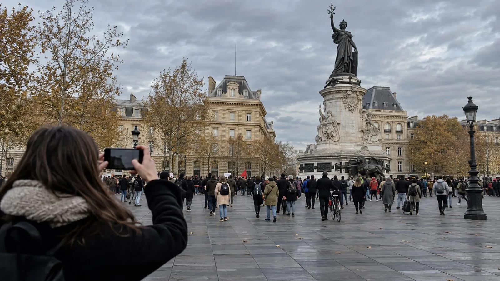 Demonstrators cross Place de la République in Paris as a bystander records the crowd. (AI-generated image / EconoTimes)