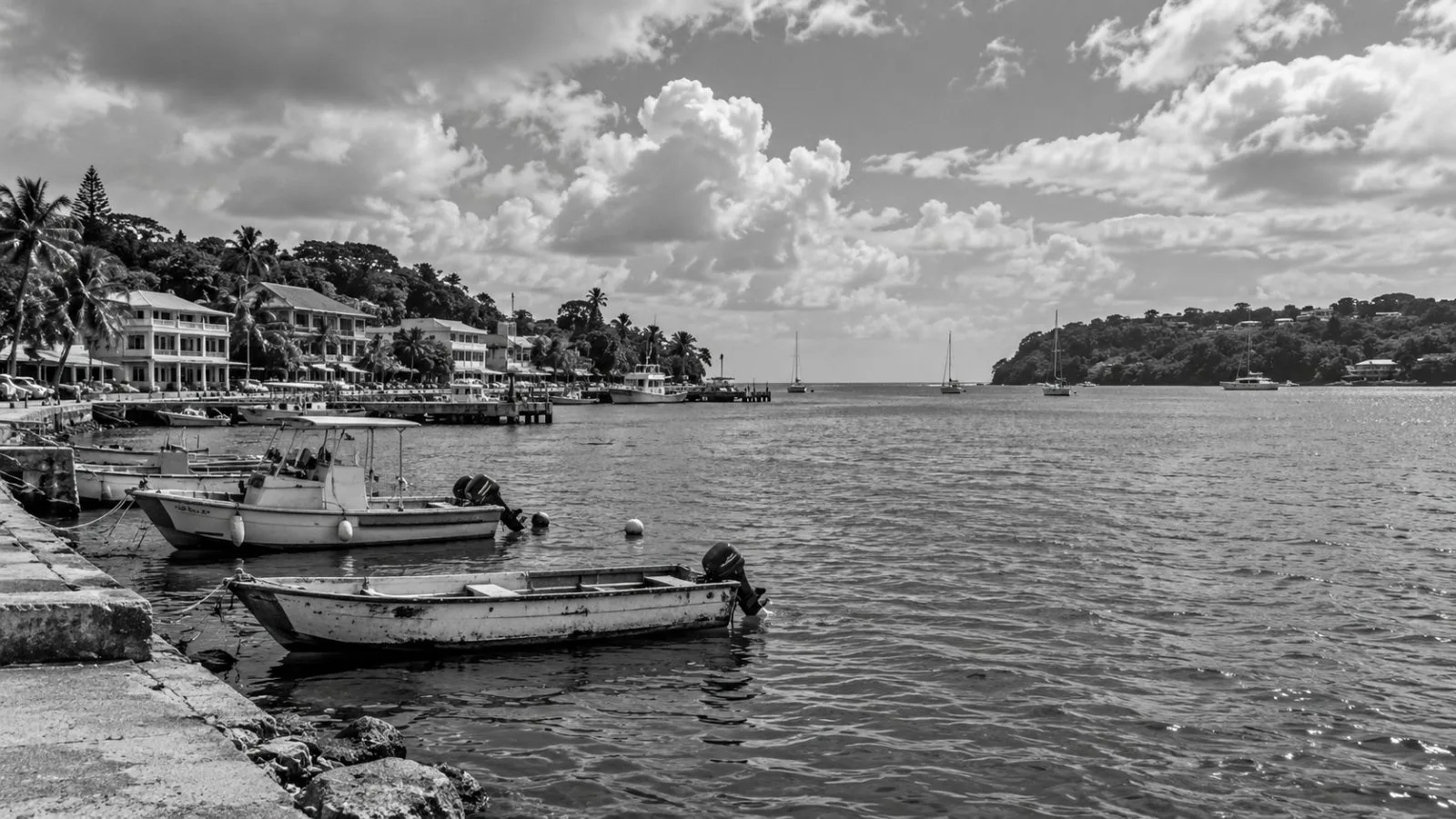 Small boats sit in Port Vila harbor as the Pacific shoreline stretches beyond, Vanuatu / EconoTimes.ai