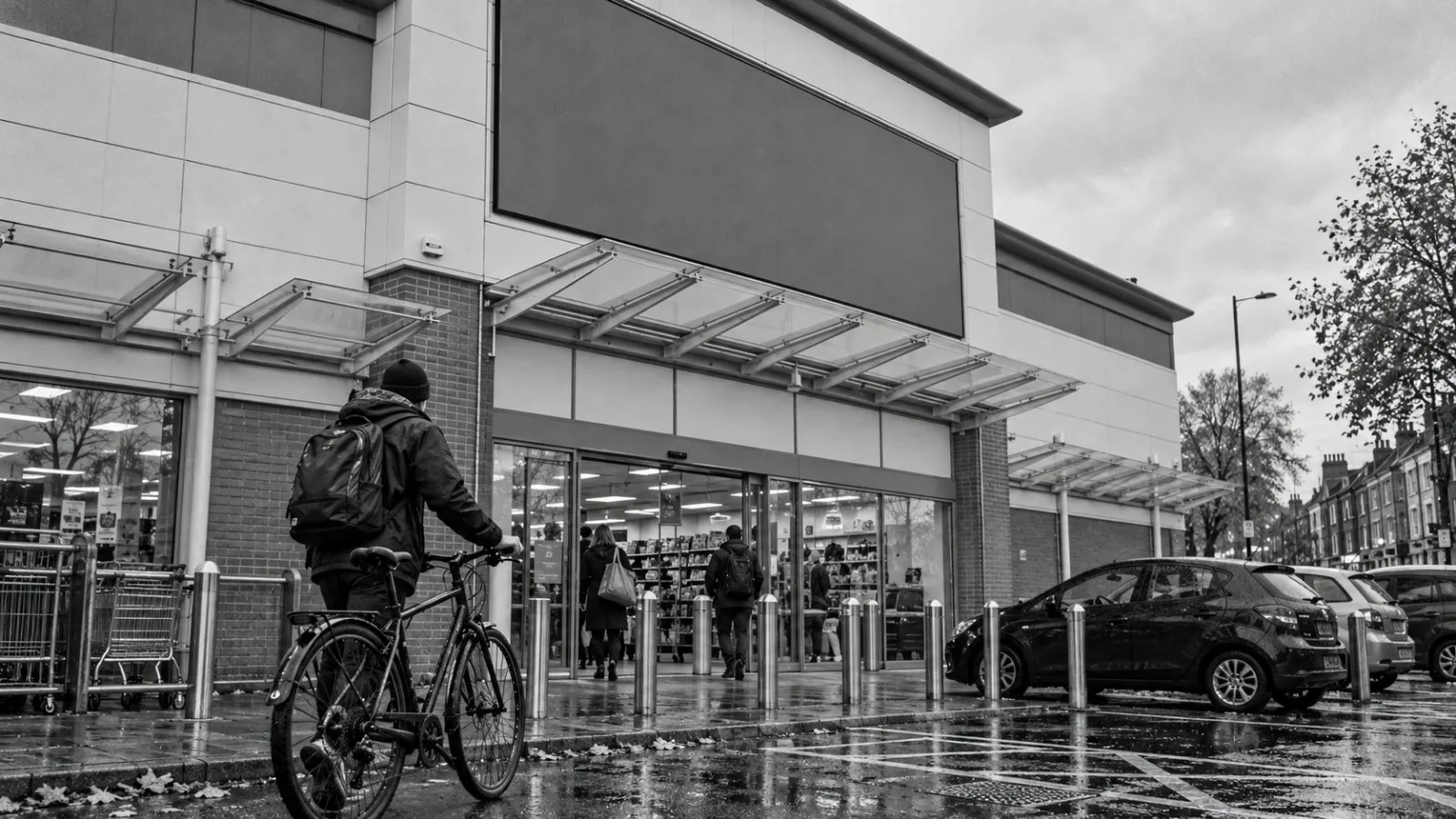 A customer wheels a bicycle outside a Halfords store in London. / EconoTimes.ai