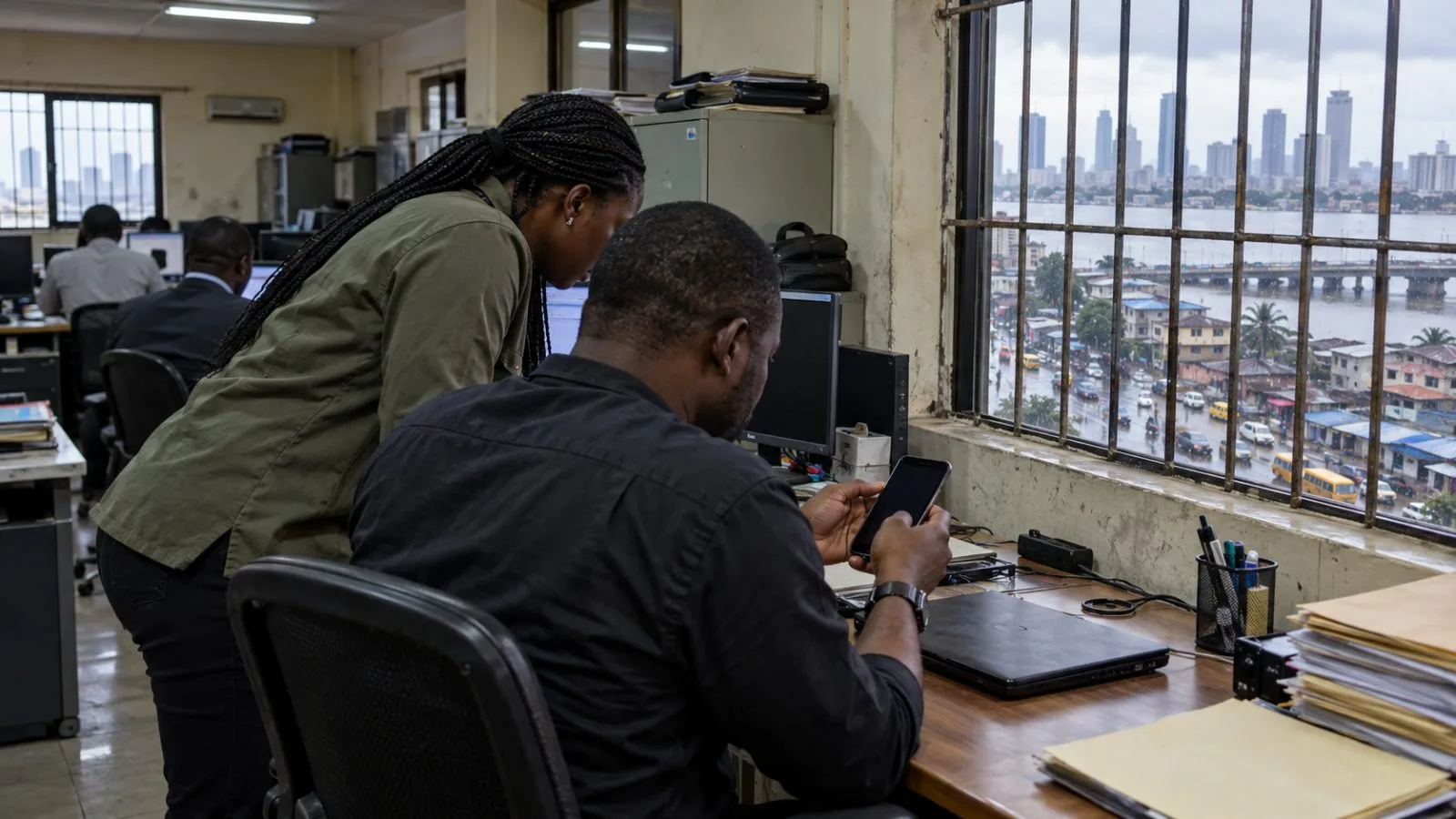 An investigator studies a mobile phone inside an office in Lagos, Nigeria. (AI-generated image / EconoTimes)