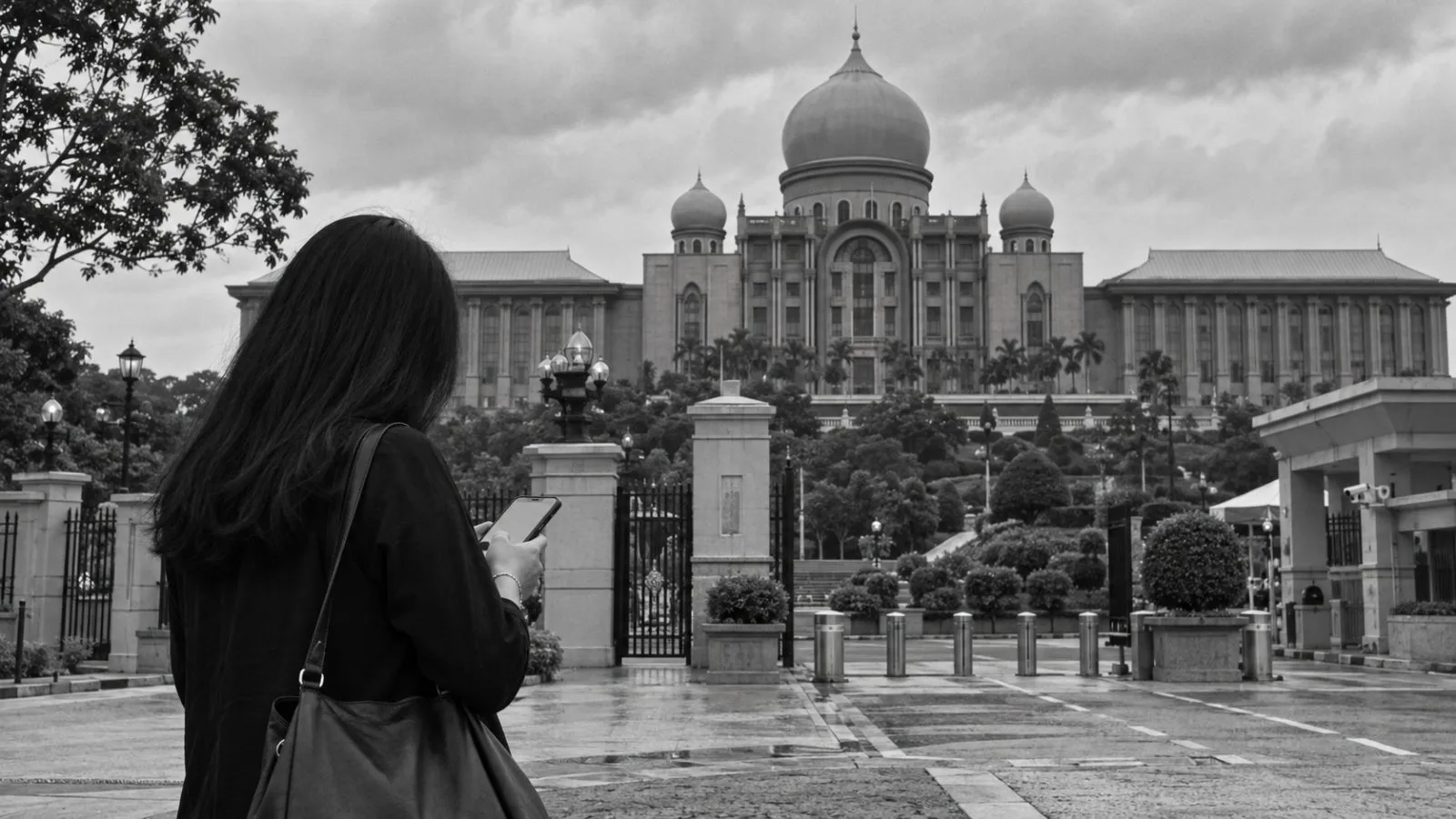 A visitor checks a phone outside Malaysia’s prime minister’s office in Putrajaya. (AI-generated image / EconoTimes)
