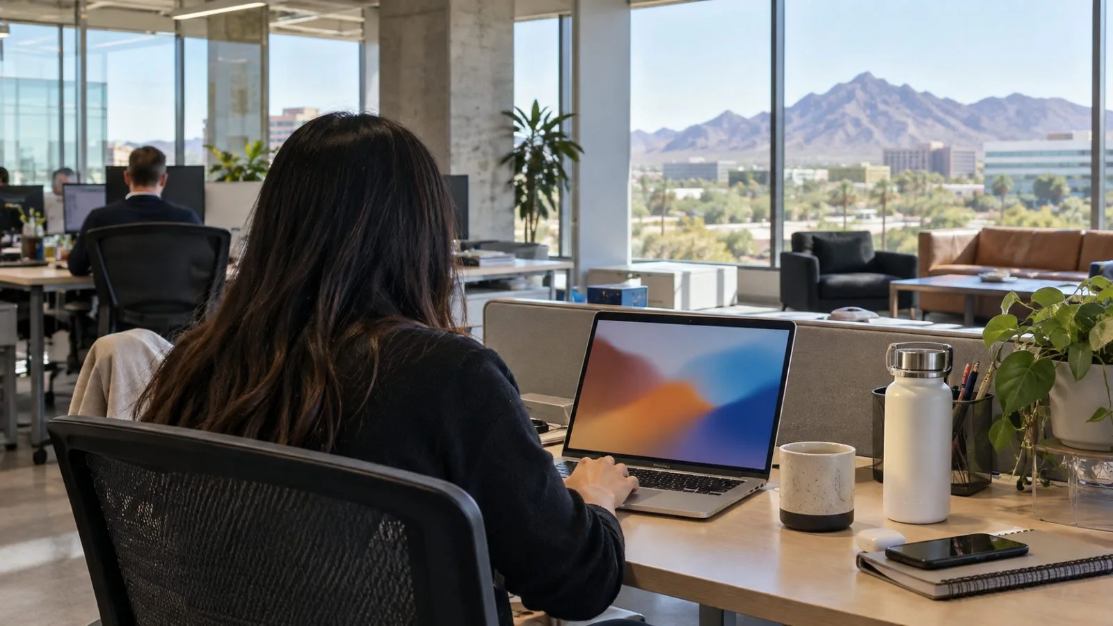 A developer tests a Node.js application on a laptop at GoDaddy’s headquarters in Tempe, Arizona. (AI-generated image / EconoTimes)