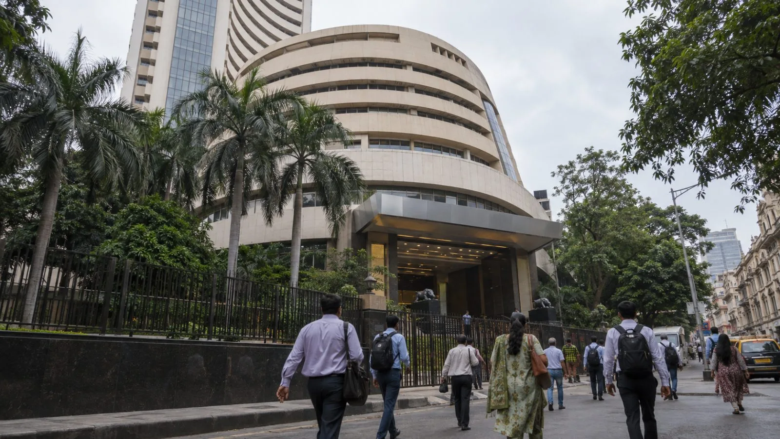 Pedestrians pass the Bombay Stock Exchange building in Mumbai after afternoon trading. (AI-generated image / EconoTimes)