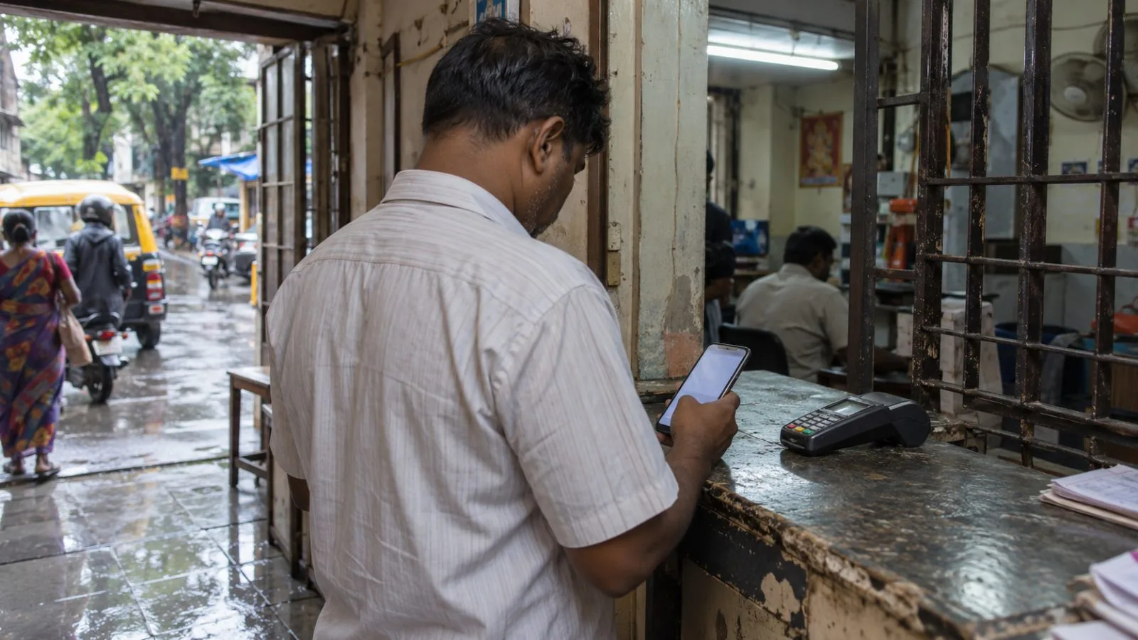 A customer checks a savings account on a phone at a neighborhood banking kiosk in Mumbai. (AI-generated image / EconoTimes)