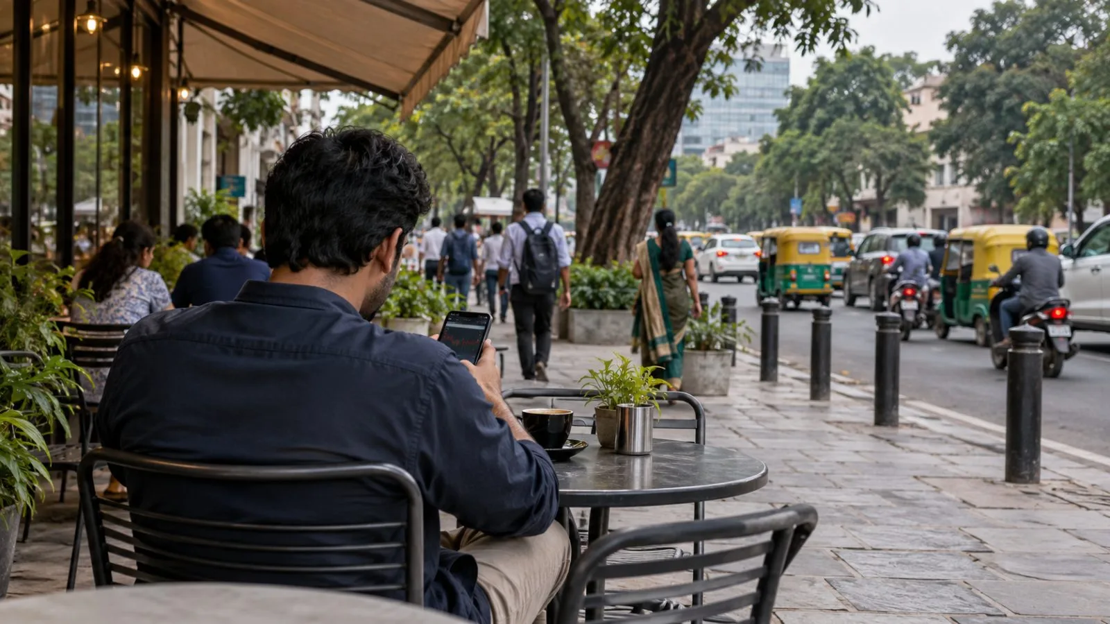A customer checks a stock-investing app at an outdoor café in Bengaluru, India / EconoTimes.ai