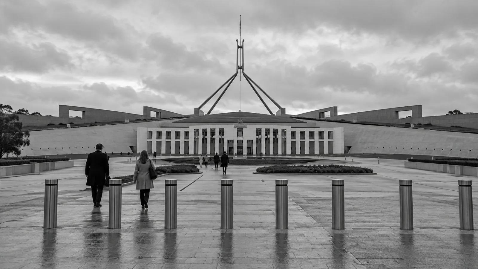 Pedestrians pass security barriers outside Parliament House in Canberra, Australia. (AI-generated image / EconoTimes)