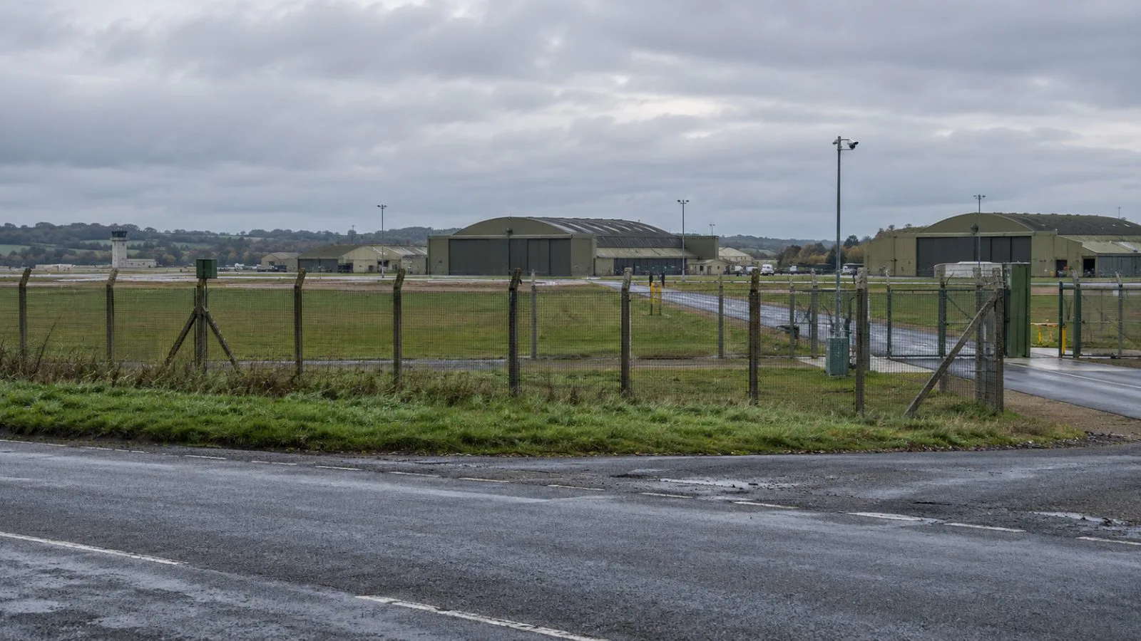 A perimeter fence borders RAF Fairford in Gloucestershire, England, under overcast skies. (AI-generated image / EconoTimes)