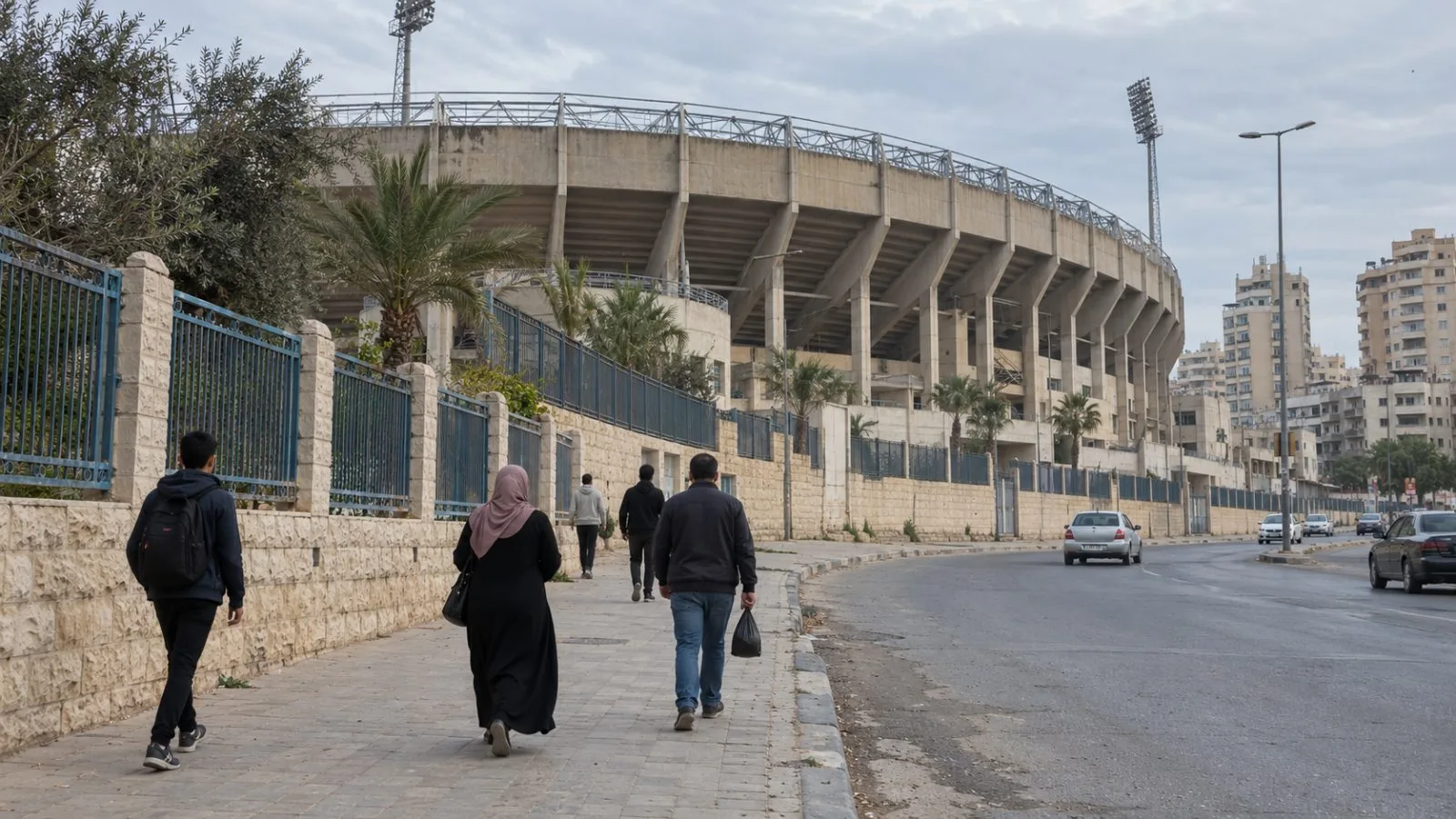Residents walk along a street beside Palestine Stadium in Gaza City's al-Rimal neighborhood (AI-generated image / EconoTimes)