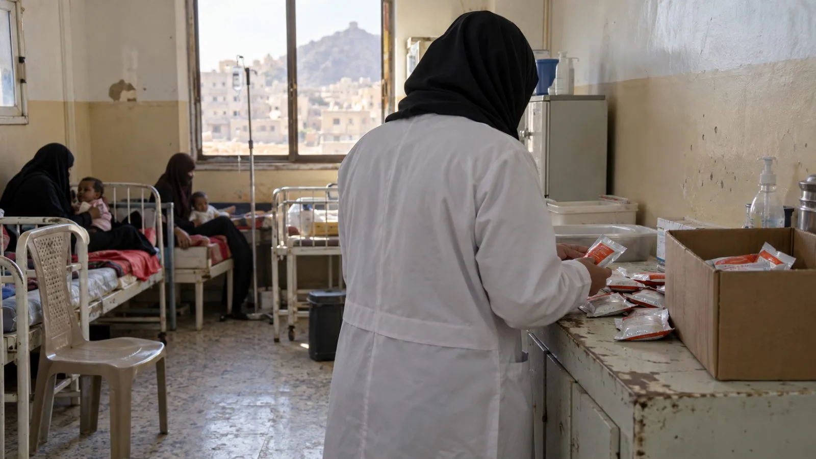 A health worker checks therapeutic food supplies at a health facility in Taiz, Yemen. (AI-generated image / EconoTimes)