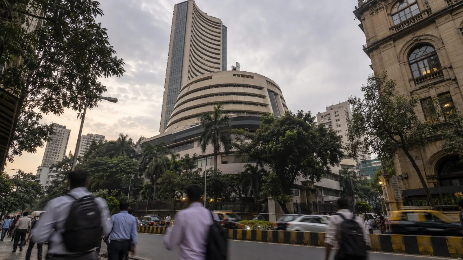 Pedestrians pass Phiroze Jeejeebhoy Towers on Dalal Street in Mumbai. (AI-generated image / EconoTimes)