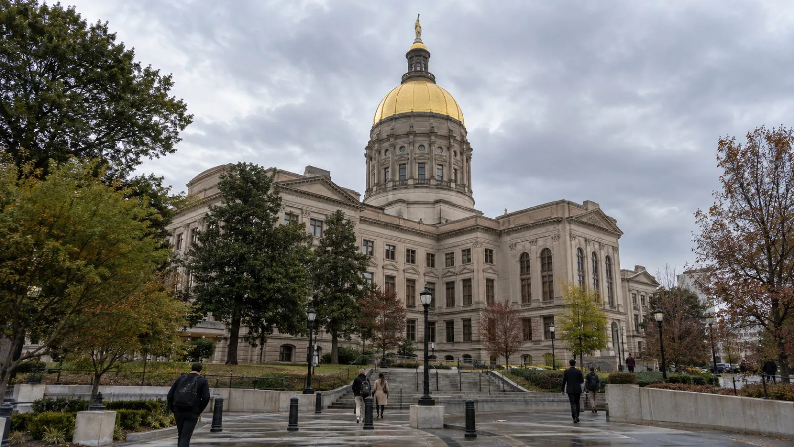 Pedestrians cross the grounds of the Georgia State Capitol in Atlanta, Georgia, beneath an overcast sky. (AI-generated image / EconoTimes)