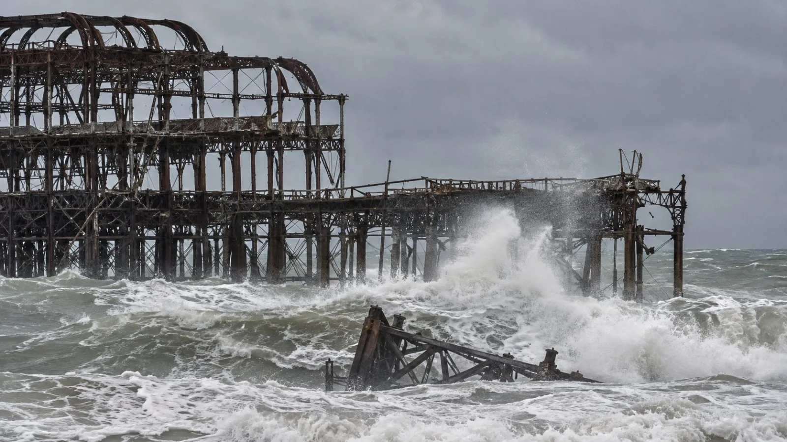 Rough seas surround Brighton's West Pier remains on England's south coast. (AI-generated image / EconoTimes)