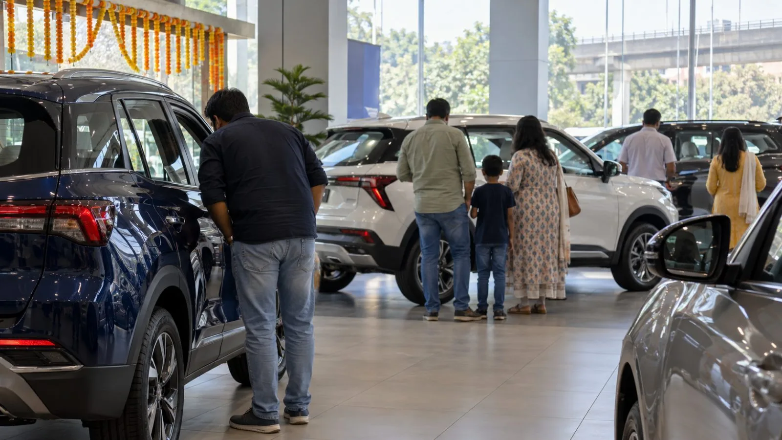 Customers inspect passenger cars inside a dealership in New Delhi, India. (AI-generated image / EconoTimes)