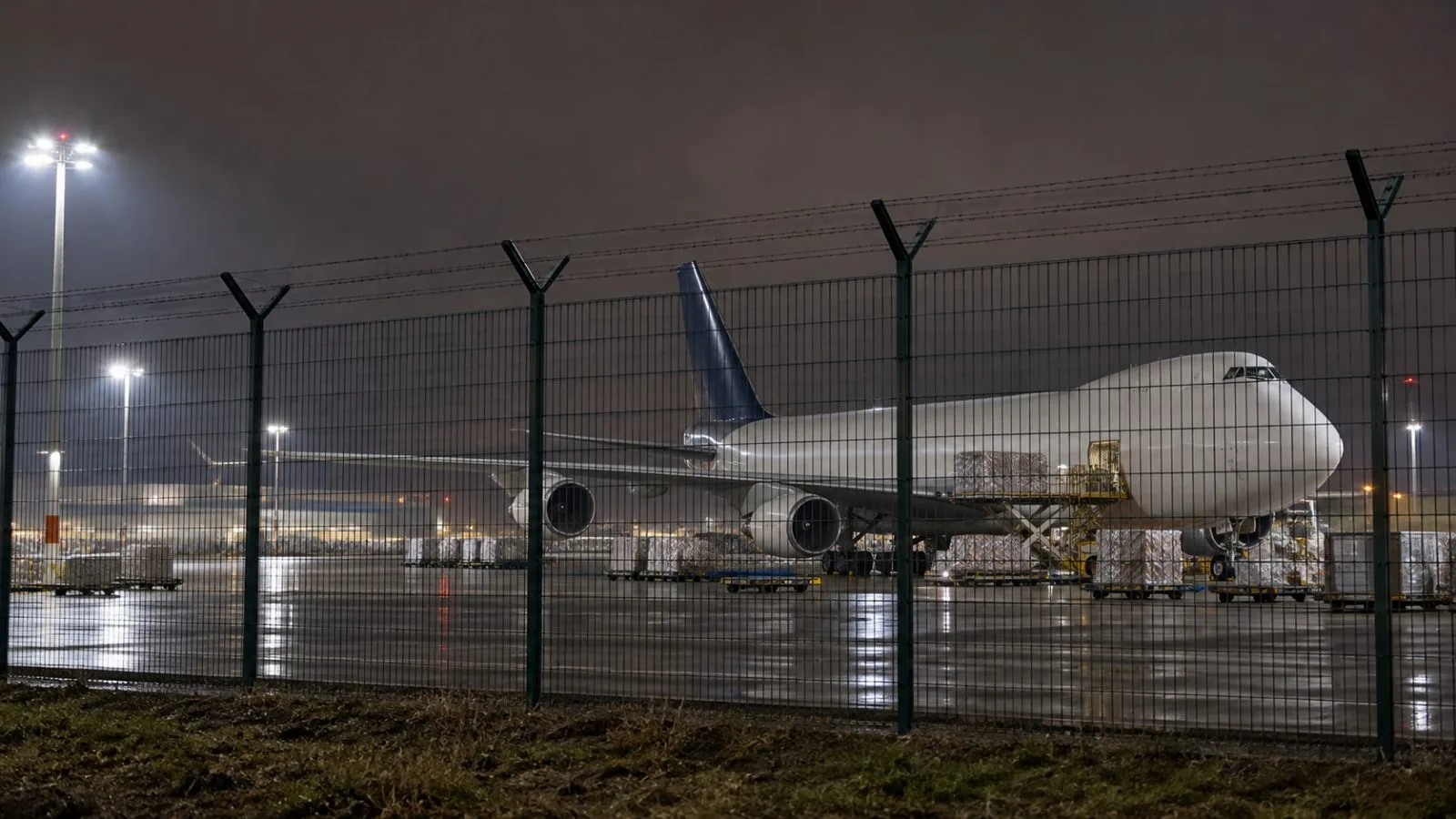 A cargo aircraft stands beyond the perimeter fence at Leipzig/Halle Airport, Germany. (AI-generated image / EconoTimes)