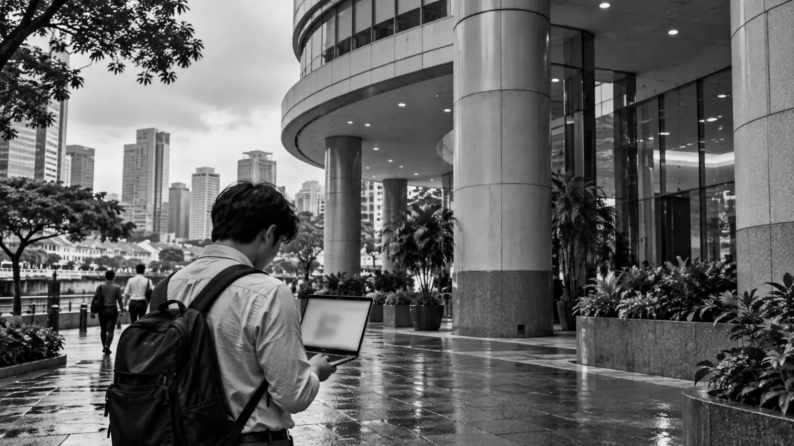 A person uses a laptop outside a building on Circular Road in Singapore. / EconoTimes.ai