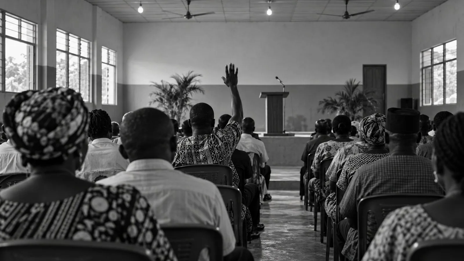 Attendees face a lectern and microphone at a town hall in Enugu, Nigeria (AI-generated image / EconoTimes)