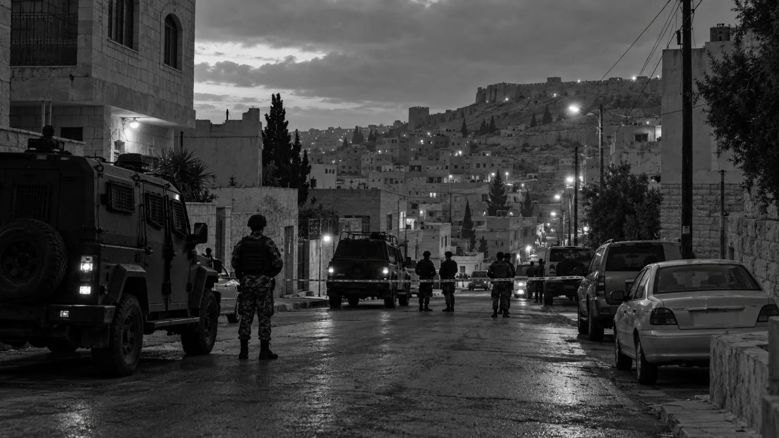 Security vehicles line a cordoned street in Karak, Jordan, at dawn. (AI-generated image / EconoTimes)