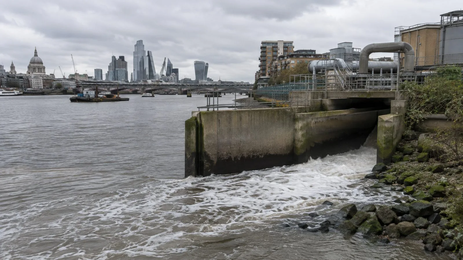 A wastewater outfall channel runs beside the River Thames in London, England (AI-generated image / EconoTimes)