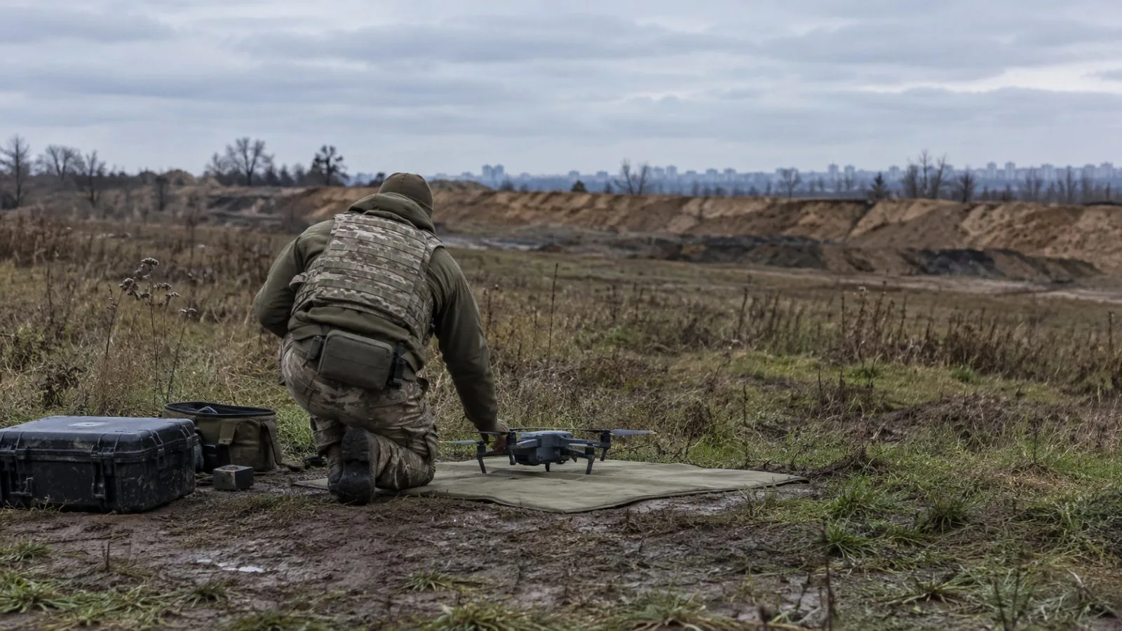 A military instructor checks a small drone at a training ground outside Kyiv, Ukraine (AI-generated image / EconoTimes)