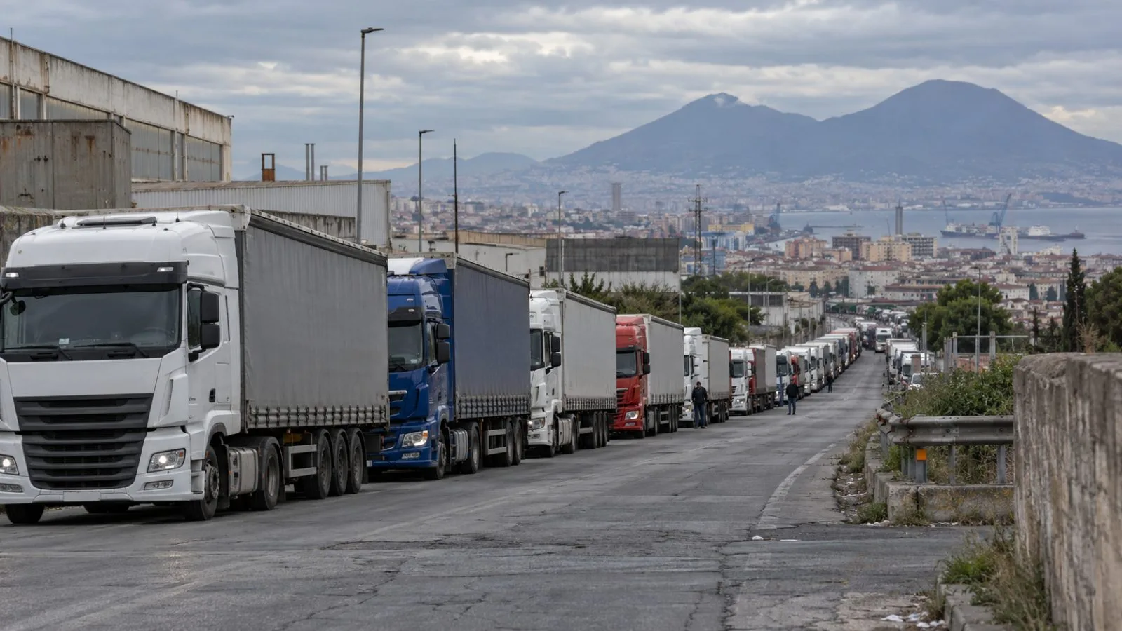 Freight trucks queue on a road outside Naples, Italy, during a diesel-cost protest. (AI-generated image / EconoTimes)