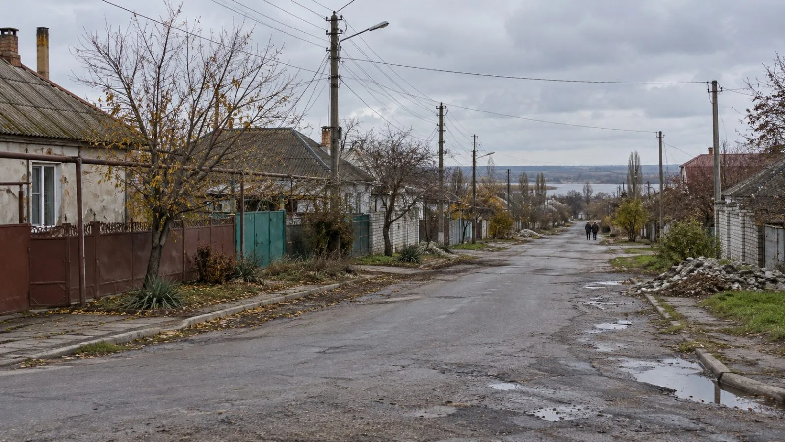 A residential road runs between homes in Oleshky, Ukraine, beneath an overcast sky. (AI-generated image / EconoTimes)