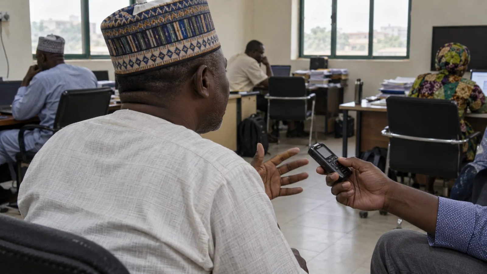 A reporter records an interview at a campaign council media room in Abuja, Nigeria (AI-generated image / EconoTimes)