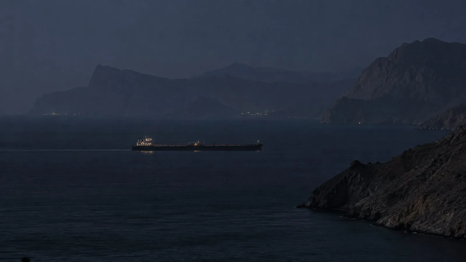 A tanker transits the Strait of Hormuz off Limah, Oman, at night. (AI-generated image / EconoTimes)