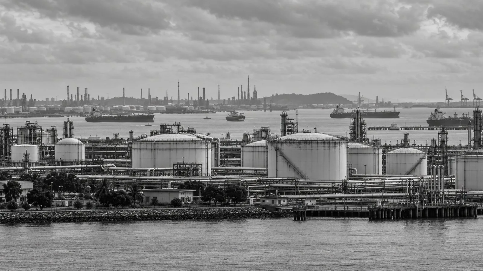 Oil storage tanks line the industrial waterfront on Jurong Island, Singapore. (AI-generated image / EconoTimes)