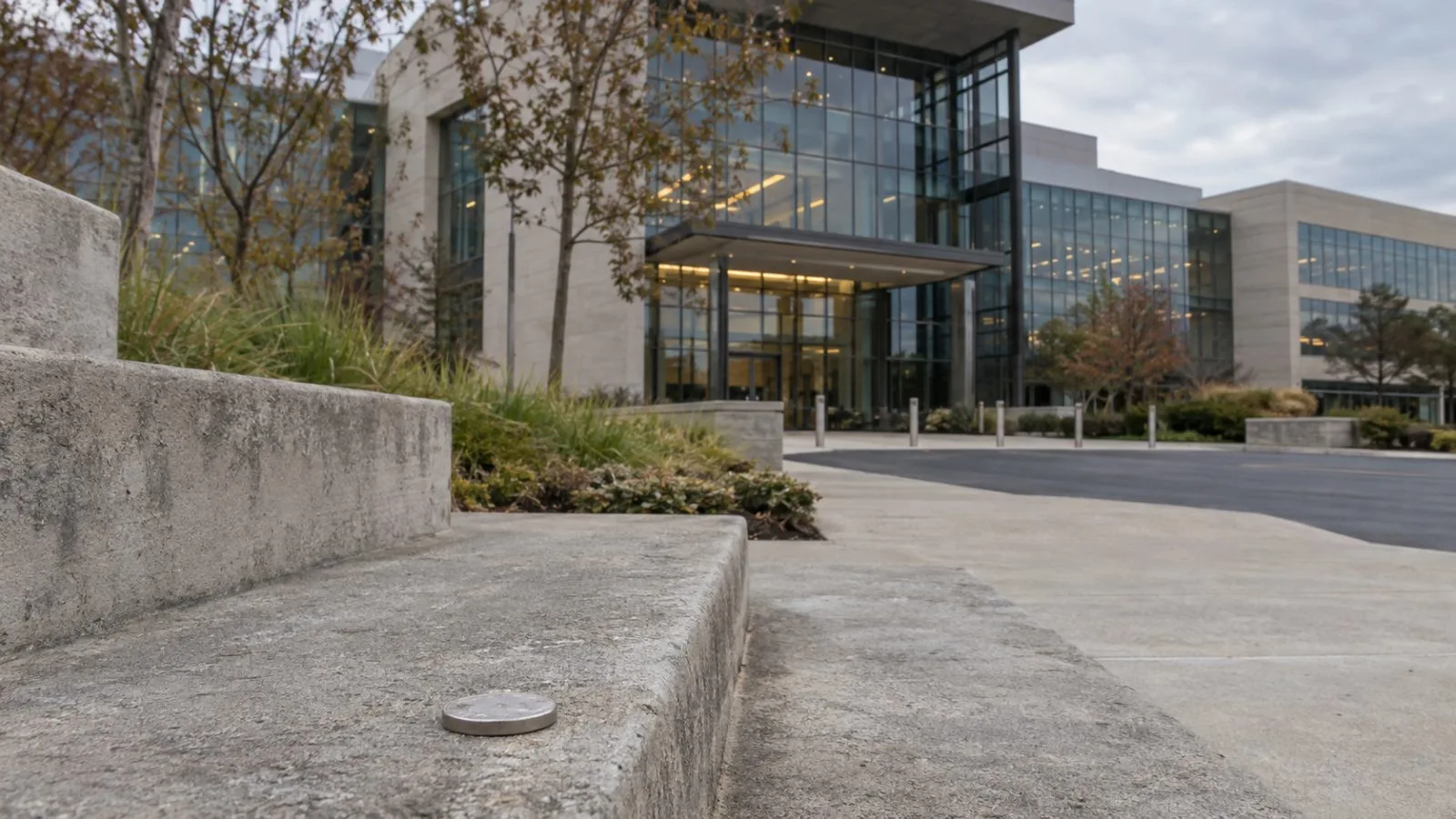 A metal token rests on a lower concrete step outside an office campus in Richardson, Texas. (AI-generated image / EconoTimes)