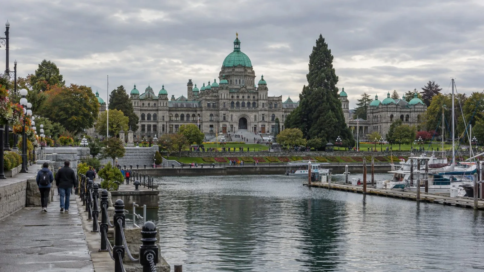 The British Columbia Parliament Buildings stand beside Victoria’s Inner Harbour under an overcast sky. (AI-generated image / EconoTimes)