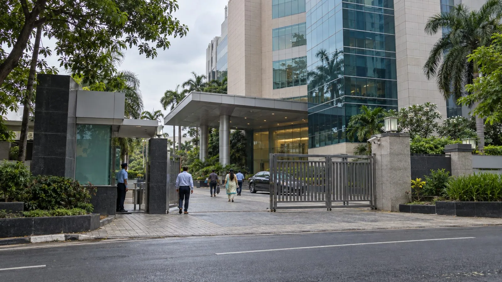 Employees pass the entrance to Murasoli Maran Towers in MRC Nagar, Chennai. (AI-generated image / EconoTimes)