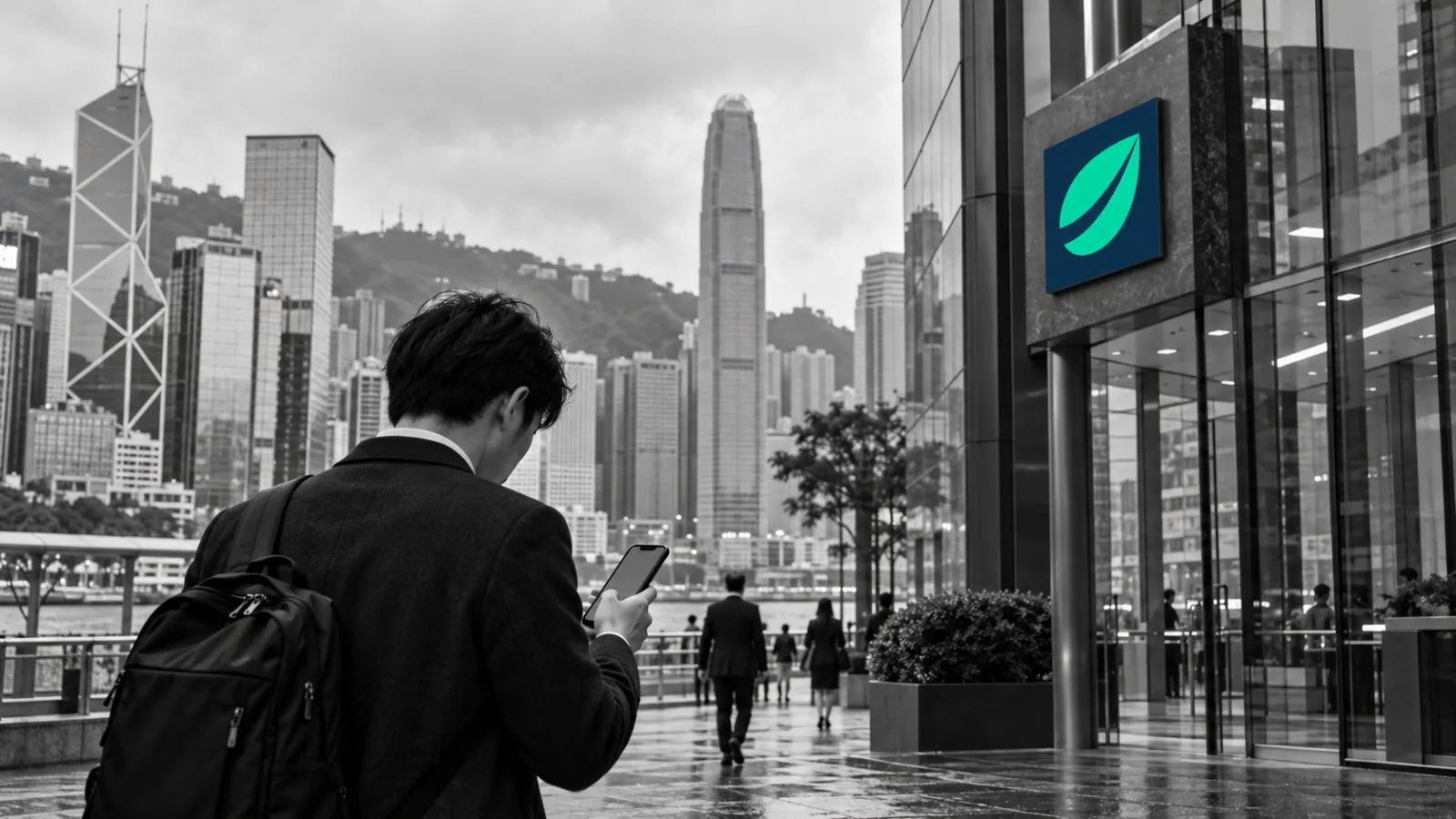 A passerby checks a smartphone outside financial buildings in Hong Kong’s Central district / EconoTimes.ai