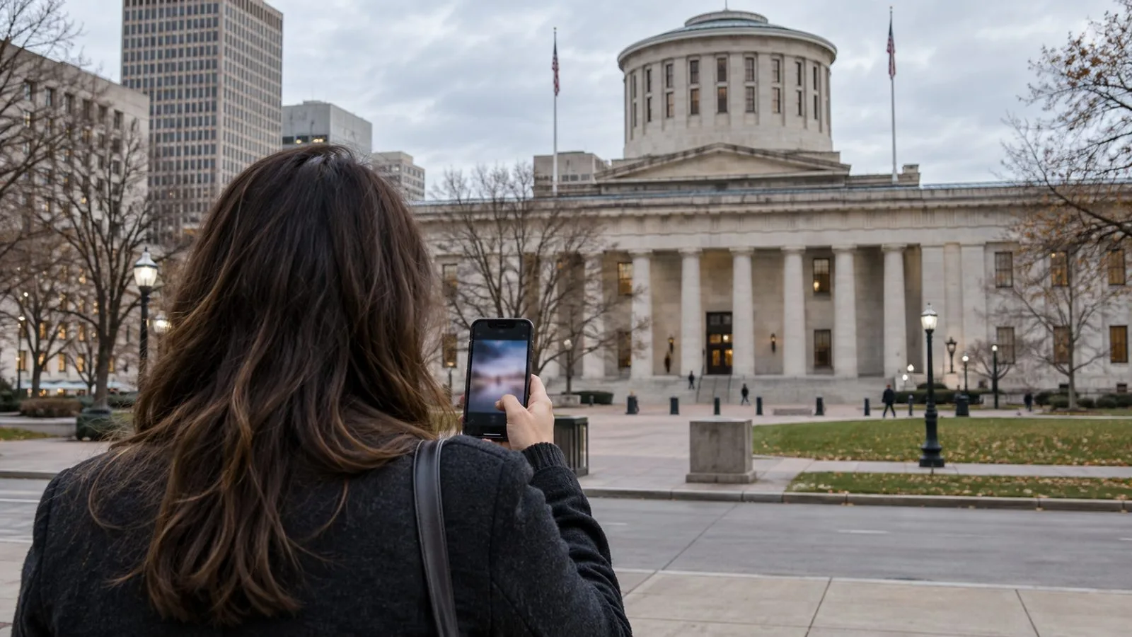 A passerby checks a phone outside the Ohio Statehouse in Columbus, Ohio. (AI-generated image / EconoTimes)