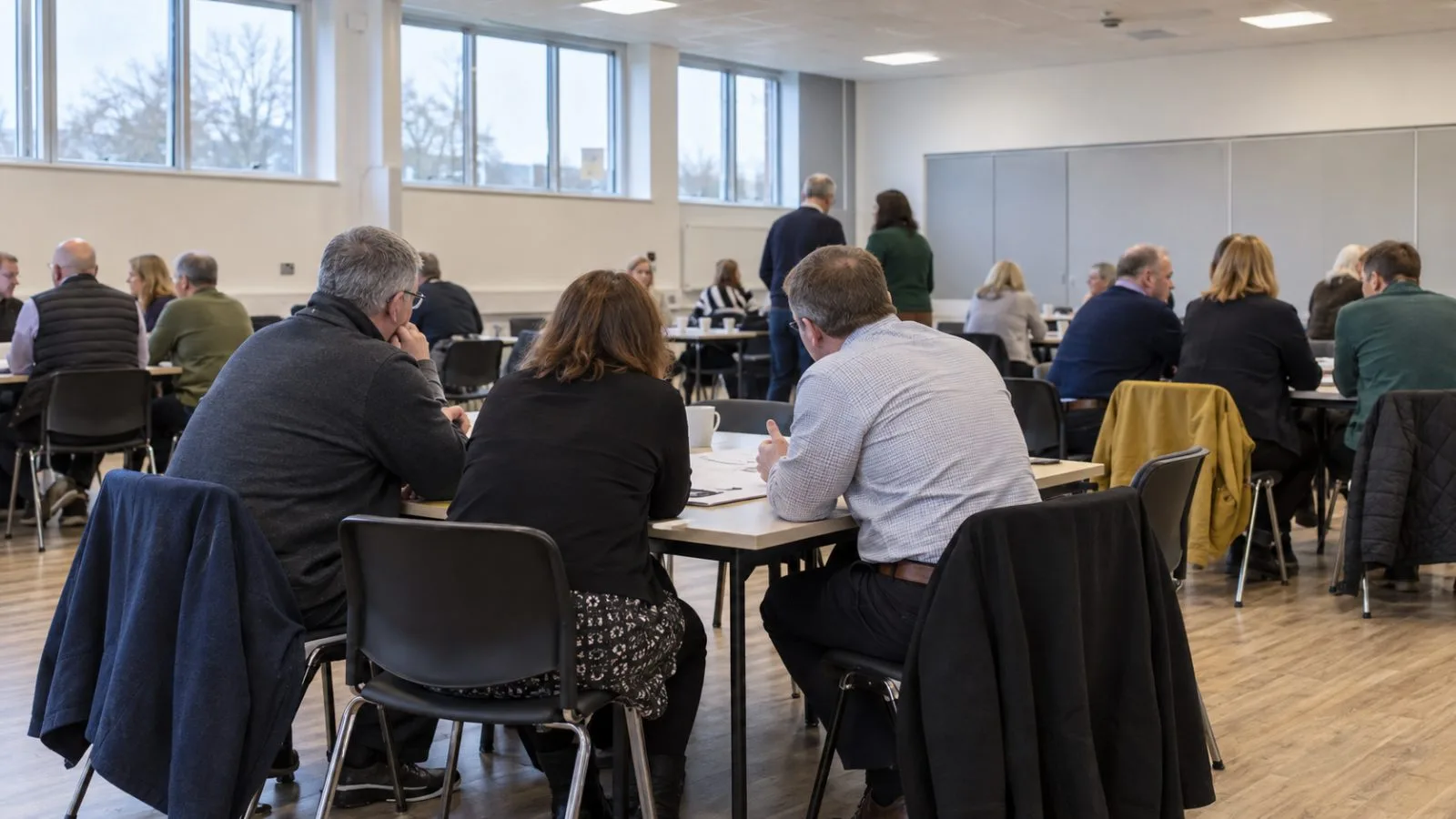 Suppliers meet around tables during a nuclear project event at Coleg Menai in Llangefni, Wales. (AI-generated image / EconoTimes)