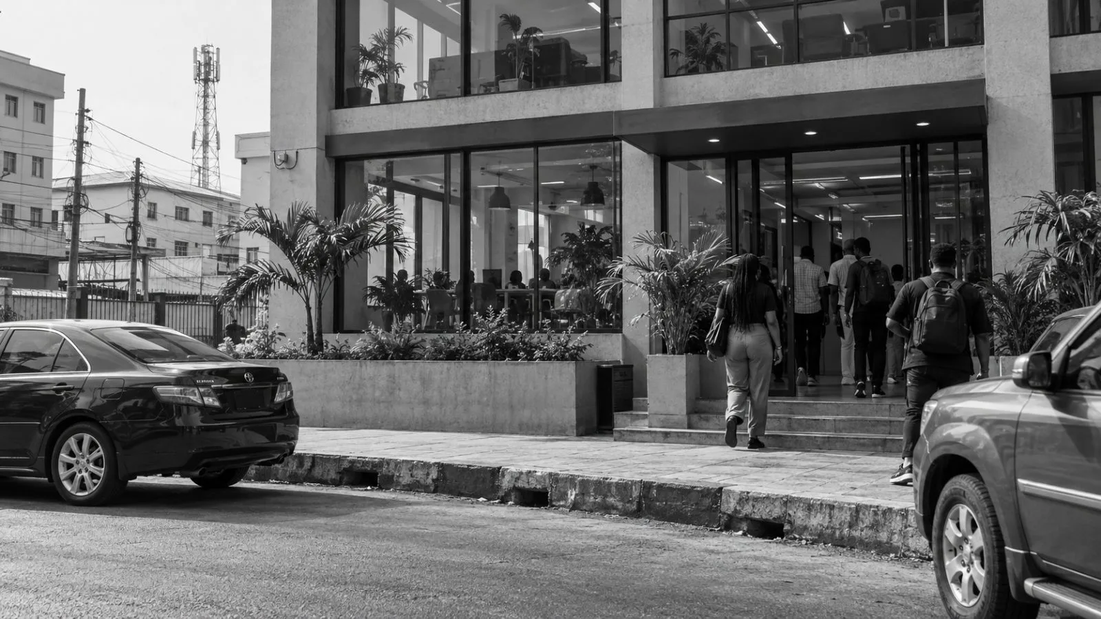 Workers enter a technology workspace in Lagos, Nigeria, on a clear morning. (AI-generated image / EconoTimes)