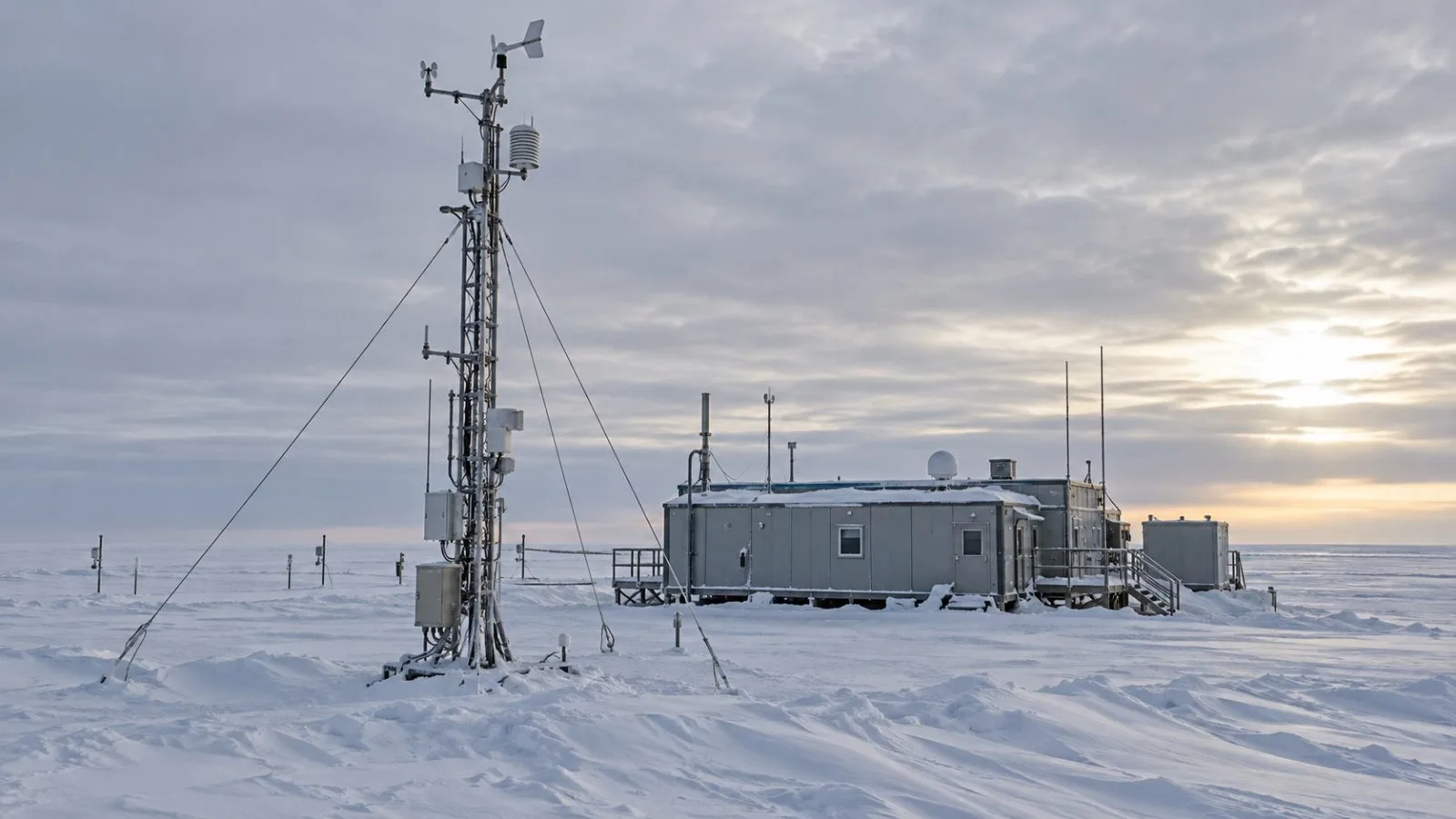 An atmospheric monitoring mast stands beside a research station on the Antarctic plateau. (AI-generated image / EconoTimes)
