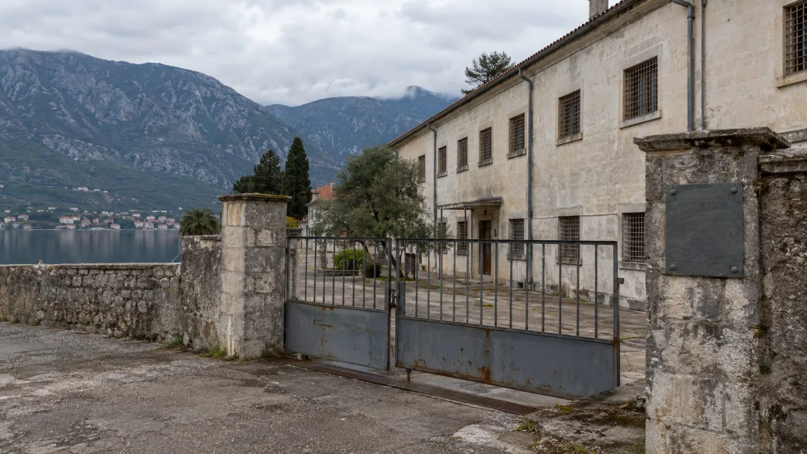 A memorial plaque stands at the former Morinj detention site near Kotor, Montenegro. (AI-generated image / EconoTimes)