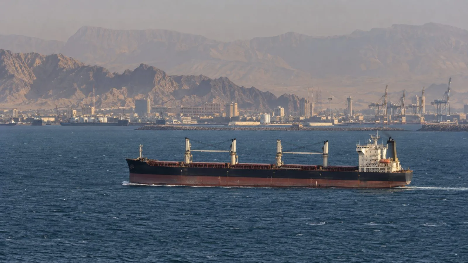 A commercial vessel crosses the Strait of Hormuz off Bandar Abbas, Iran, in hazy afternoon light (AI-generated image / EconoTimes)