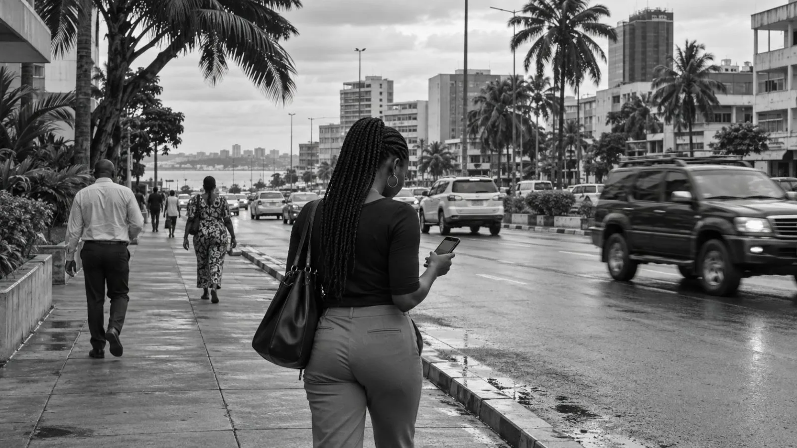 A pedestrian checks a smartphone on a central Libreville sidewalk as traffic passes. (AI-generated image / EconoTimes)