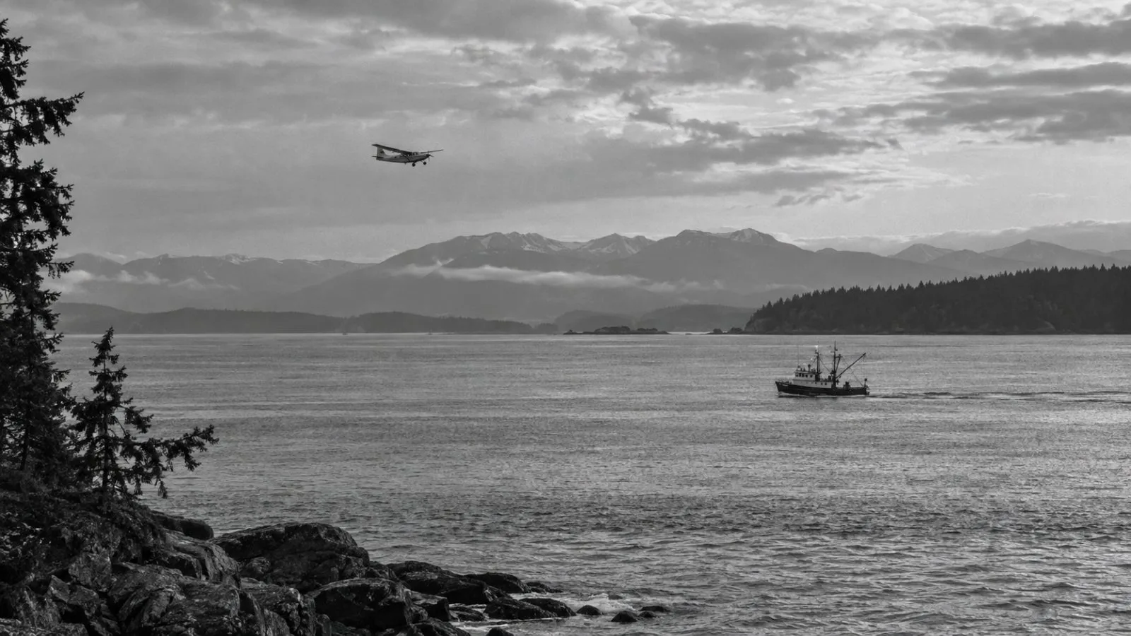 A vessel crosses the Strait of Georgia off Vancouver, British Columbia, beneath a passing aircraft. (AI-generated image / EconoTimes)