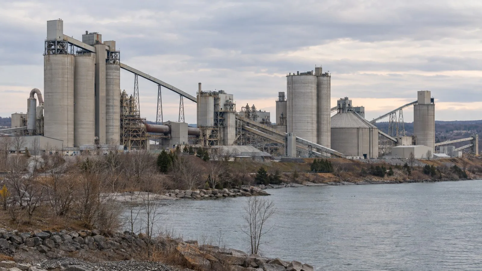 Cement silos rise above the St. Marys Cement plant in Bowmanville, Ontario. (AI-generated image / EconoTimes)