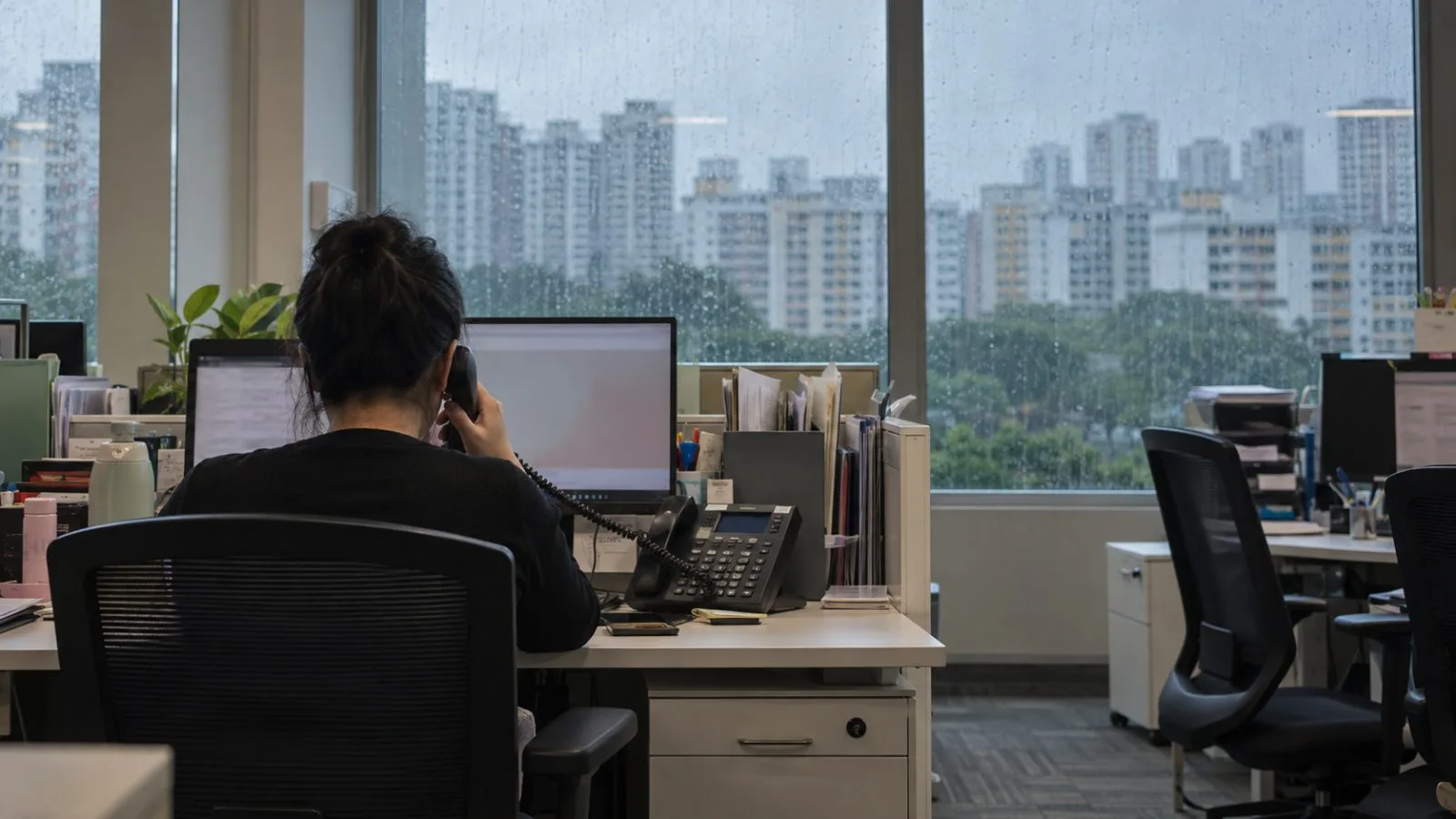 A helpline operator answers a call inside a public service room in Singapore. (AI-generated image / EconoTimes)